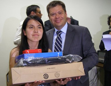 El Subdirector del Senadis, Oscar Mellado realiza la entrega de un  notebook a una de las personas beneficiadas.