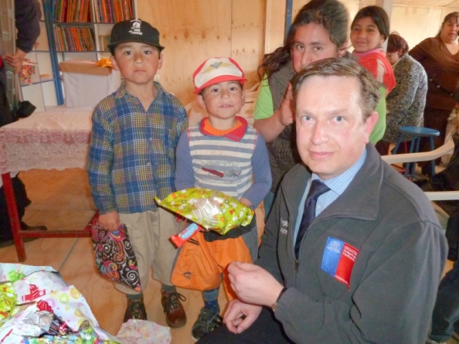 Director Regional Sergio Arellano entrega juguetes a niños del campamento de Angelmó.