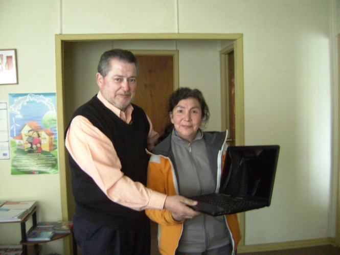 Julio bascur junto a madre de persona con discapacidad que recibió un notebook