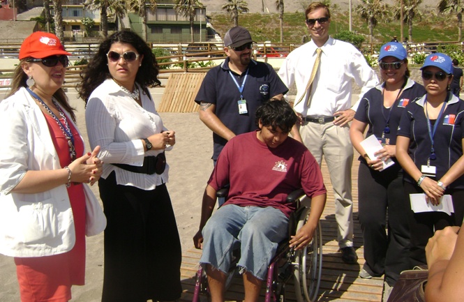 Autoridades regionales junto a un joven en silla de ruedas en una de las rampas que existen en la playa.