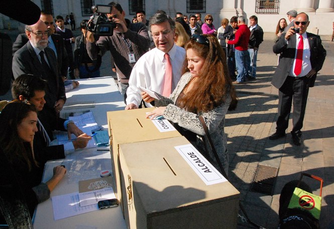 Ministro Lavín junto a persona ciega en el lanzamiento del nuevo voto con sistema Braille.
