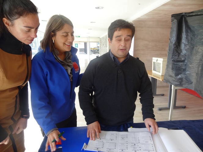 Autoridades acompañan a persona con discapacidad visual en lanzamiento de voto con sistema Braille