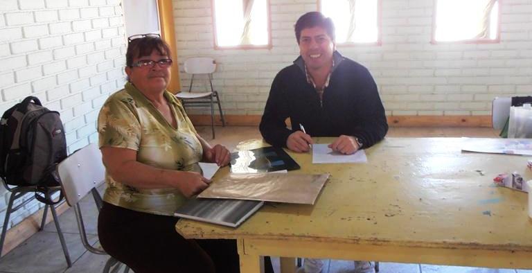 El profesional de la Dirección Regional, Christian Cortés entrega información a persona de la comuna de Huara. 