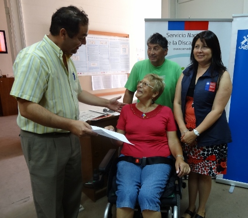 Director Regional de Tarapacá, Guillermo Cortés haciendo entrega de la silla electrónica a Iris Varas. 