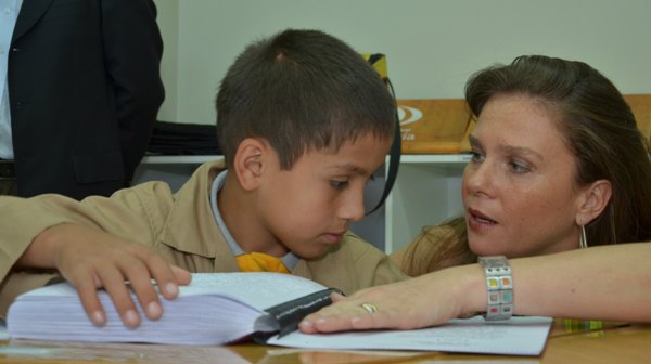 La Directora Nacional del Senadis junto a uno de los alumnos leyendo Papelucho en sistema Braille