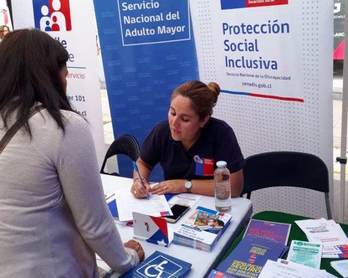 Profesional de Senadis Jocelyn Franco entrega información en el stand del Servicio.