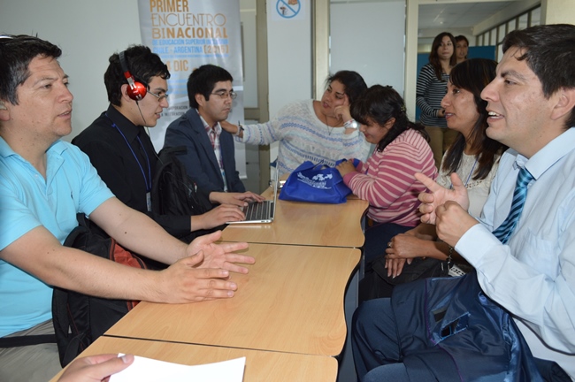 Fotografía de estudiantes asistentes al evento interactuando entre ellos. 