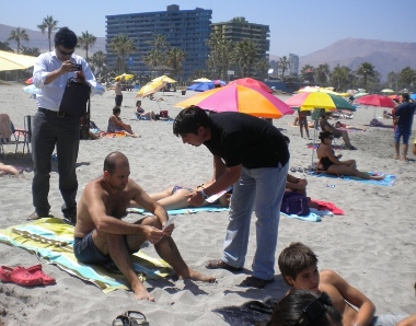 El Coordinador del Senadis en la Región de Tarapacá, Christian Cortés entrega material informativo a los bañistas en la playa. 