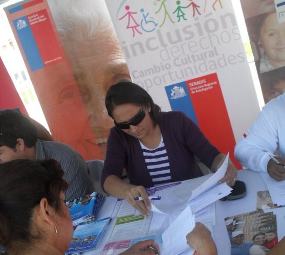 En el stand Senadis Yasna Salvo entrega información de los programas del Servicio.