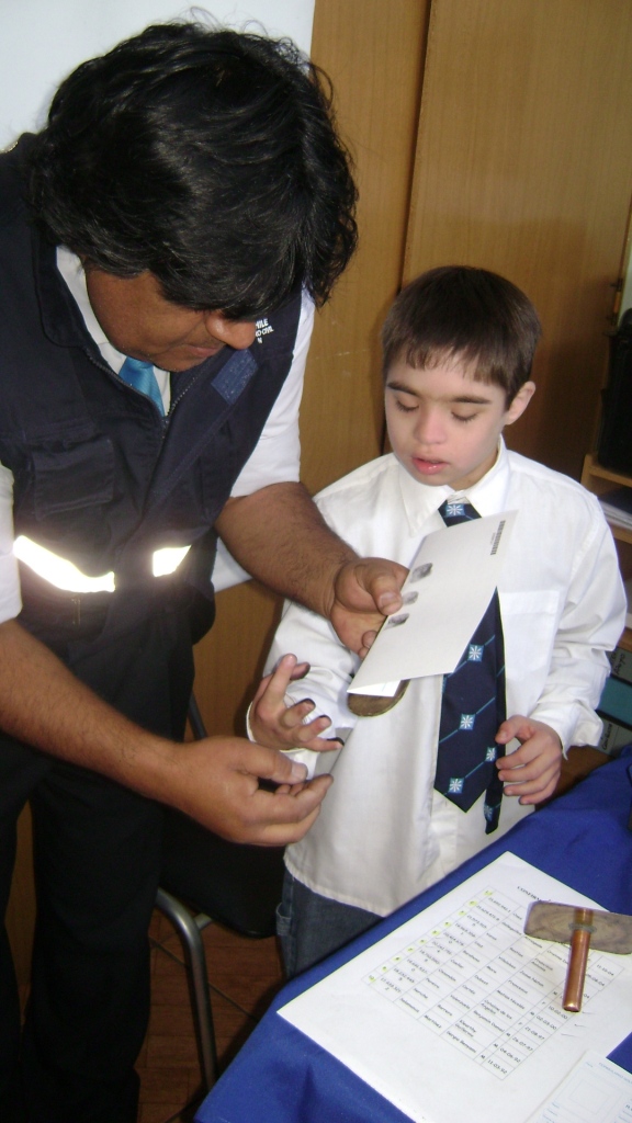 Aparece un niño con síndrome de Down a quien le están pintando los dedos para timbrar