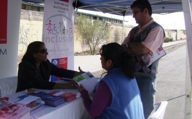 La profesional del Senadis Antofagasta, Yasna Salvo entrega información en el stand del servicio.