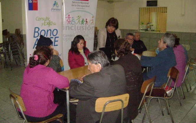 La profesional de FONASA realizando la charla informativa a personas con discapacidad visual.