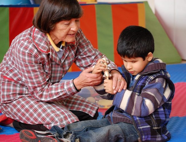 Educadora del colegio Santa Lucía junto a un alumno con discapacidad visual.