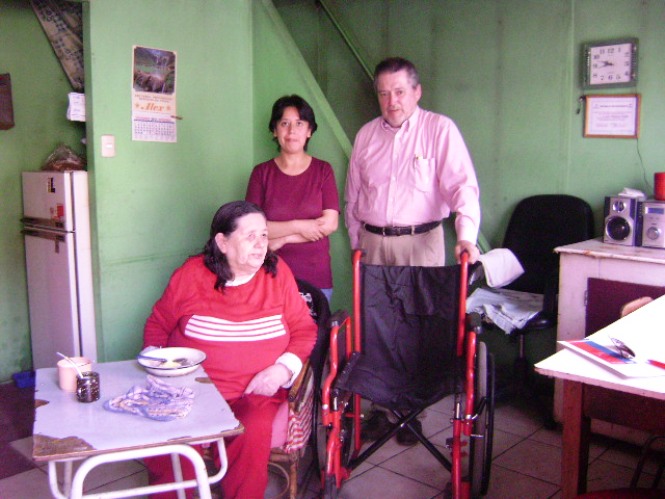 Julio bascur entrega silla de ruedas a madre del grupo familiar
