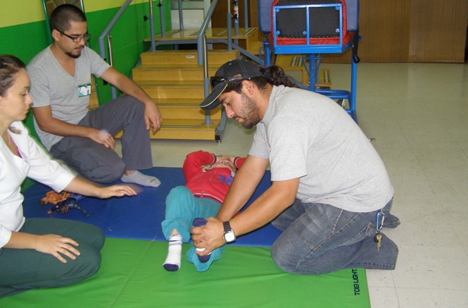 Niño del Instituto Nacional de Rehabilitación Pedro Aguirre Cerda junto a su padre y terapeutas