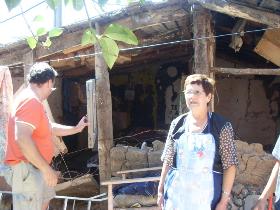 Una de las personas afectadas junto a su casa que resultó con diversos daños producto del terremoto.