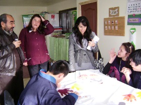 Las autoridades regionales presencian el trabajo realizado por dos jóvenes con discapacidad mental, beneficiarios del proyecto.