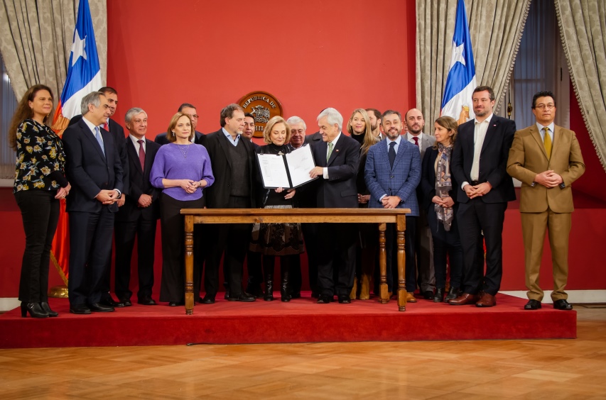 Presidente Piñera y Primera Dama muestran documento de la ley promulgada en compañía a autoridades. 