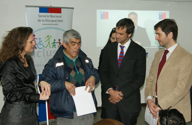 Autoridades entregándole el folleto en Braille a Jorge Villagra. 