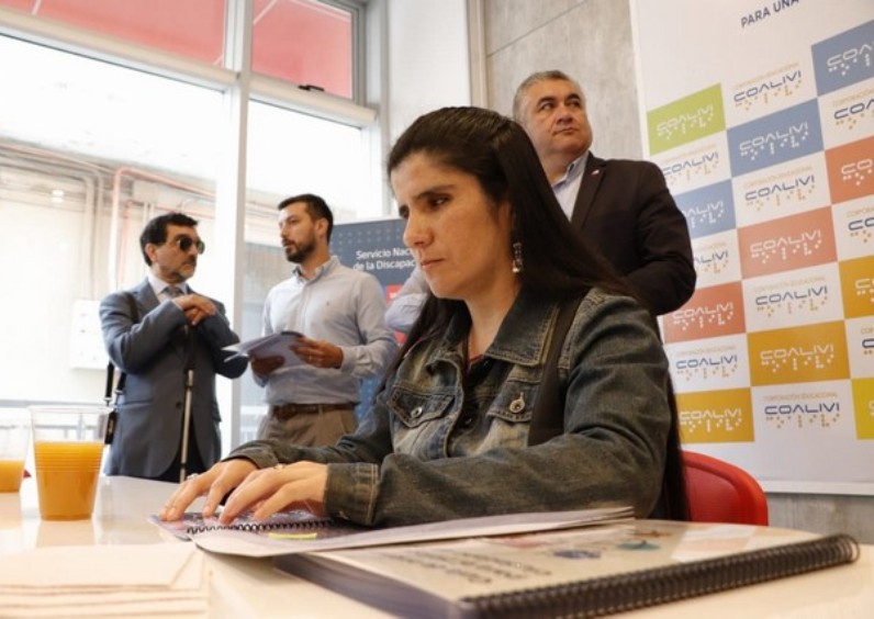 Mujer con discapacidad visual accede al material en sistema braille. 