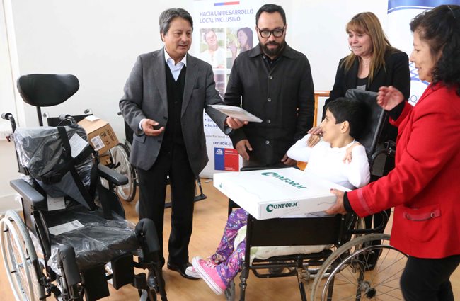Fotografía del Director Regional haciendo entrega de una ayuda técnica a un joven con discapacidad. 