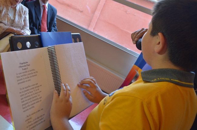 Estudiante con discapacidad visual leyendo Papelucho en sistema Braille.