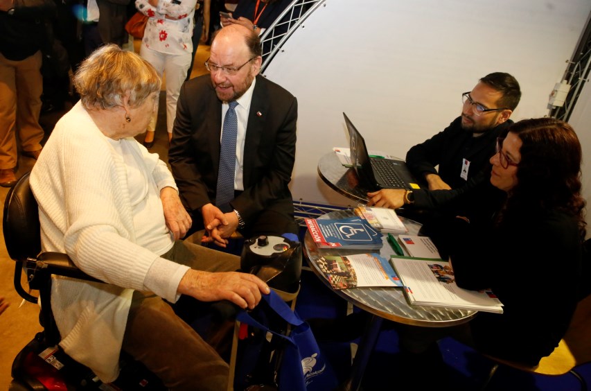 Ministro Moreno conversa con una señora con discapacidad en el stand de SENADIS. 