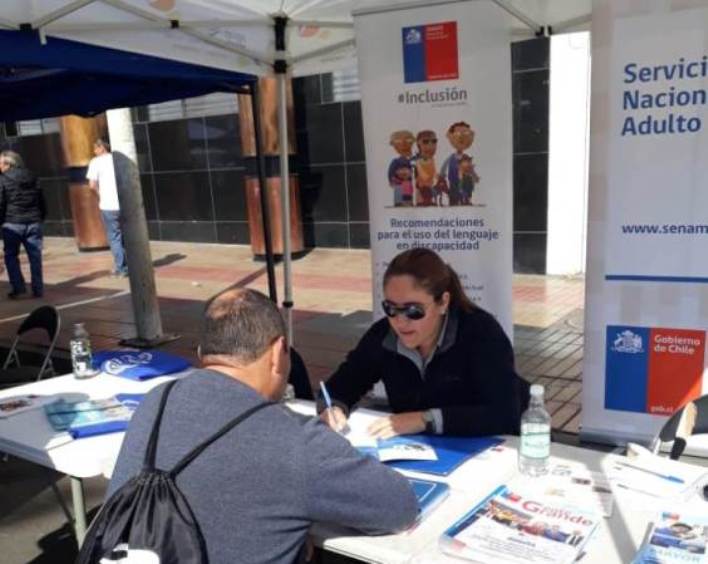 Profesional de Senadis Jocelyn Franco entrega información en el stand del Servicio.